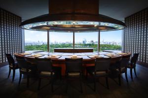 
a dining room table with a large window at Hotel New Otani Osaka in Osaka
