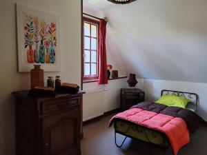 a bedroom with a bed and a dresser and a window at Les colombages bis in Pazayac