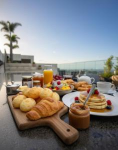 a table topped with plates of pastries and pancakes at Palazzo Torquetti in Belo Horizonte