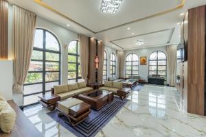 a living room filled with furniture and windows at Loc Binh Hotel in Thôn Phú An