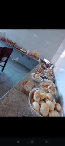 a counter with a bunch of bowls of food at Pousada 4Estações- Caldas Novas in Caldas Novas