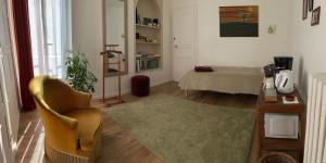 a living room with a table and a chair at Suite - Chambre Cherry Plum in Coulommiers