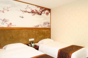 2 camas en una habitación con un cuadro en la pared en Guangzhou JinTang Hotel, en Guangzhou