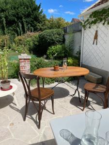 a wooden table and chairs on a patio at Suite - Chambre Cherry Plum in Coulommiers