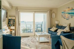 a living room with a blue couch and a table at Bayfront Bliss Your Waterfront Getaway in Ocean City