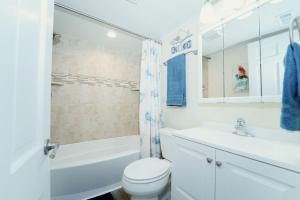 a white bathroom with a toilet and a tub and a sink at Bayfront Bliss Your Waterfront Getaway in Ocean City +46 photos