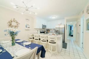 a white kitchen with a table and chairs and a refrigerator at Bayfront Bliss Your Waterfront Getaway in Ocean City