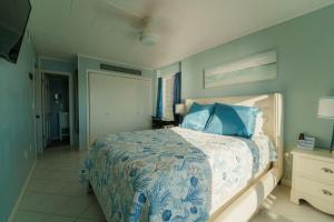 a bedroom with a bed with a blue and white comforter at Bayfront Bliss Your Waterfront Getaway in Ocean City