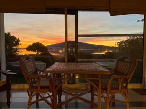 a table and chairs on a porch with a view of the sunset at Vistas do Minho no Caminho de Santiago in Caminha