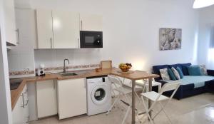 a kitchen with a washing machine and a table at La Abundancia in La Restinga