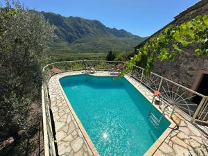 a swimming pool with mountains in the background at Ethno House Ivanovic in Virpazar