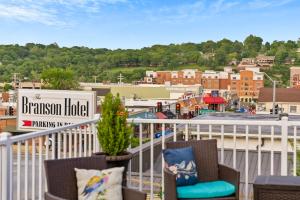 a balcony with two chairs and a sign that reads dinosaur hotel at Dreams2Reality | Historic Branson Hotel - Haven Suite - Downtown in Branson +14 photos