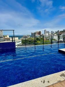 a large swimming pool on the roof of a building at Apartamento novo aconchegante na Ondina in Salvador
