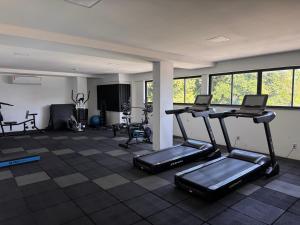 a gym with two treadmills and ellipticals in a room at Apartamento novo aconchegante na Ondina in Salvador