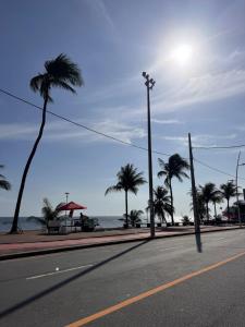 an empty street with palm trees and a street light at Apartamento novo aconchegante na Ondina in Salvador