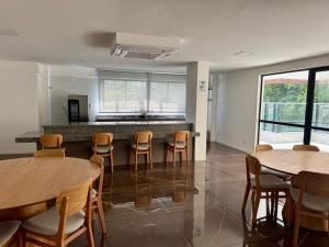 a room with tables and chairs and a counter at Apartamento novo aconchegante na Ondina in Salvador