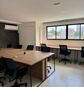 a conference room with tables and chairs and windows at Apartamento novo aconchegante na Ondina in Salvador +12 photos