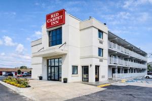 a large white building with a red sign on it at Value Extended Stay in Maple Shade