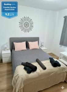 a bedroom with a bed with two remotes on it at Sonnen & Mar in Antigua