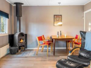 a living room with a table and a wood stove at Tranquil Retreat in Skaerbaek in Skærbæk +29 photos