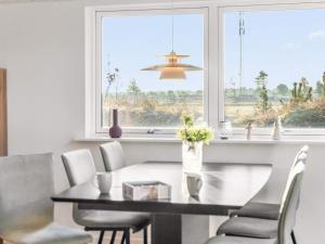 a dining room with a table and chairs and a window at 5 star holiday home in Rømø in Toftum