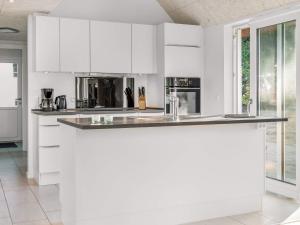 a kitchen with white cabinets and a counter top at 5 star holiday home in Rømø in Toftum