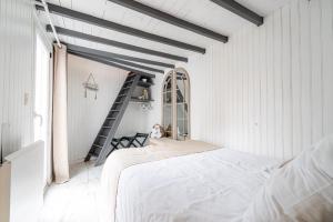 a white bedroom with a bed and a ladder at Prestige Étretat in Étretat
