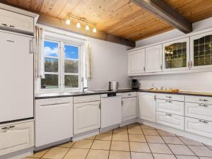 a white kitchen with white cabinets and windows at 5 star holiday home in Gram in Gram