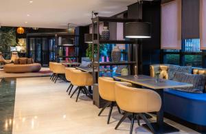 a restaurant with tables and chairs in a room at Leonardo Hotel Madrid City Center in Madrid