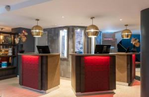 a hotel lobby with a reception desk with red doors at Leonardo Hotel Madrid City Center in Madrid