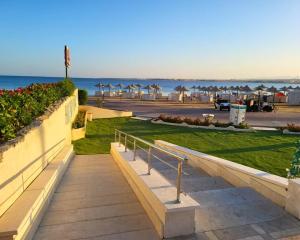 a walkway leading to the beach with umbrellas at Beachfront luxury Palm Beach Piazza Private Beach in Hurghada
