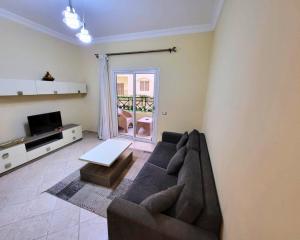 a living room with a couch and a tv at Beachfront luxury Palm Beach Piazza Private Beach in Hurghada