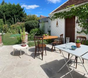 a patio with a table and two tables and chairs at Suite - Chambre Cherry Plum in Coulommiers