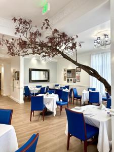 a restaurant with white tables and blue chairs at Wyndham Gettysburg Hotel & Conference Center in Gettysburg