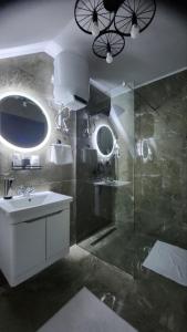 a bathroom with a sink and a glass shower at Crassula Lux 4 in Surčin +25 photos