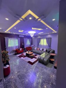 a large living room with couches and tables at Shortlet247 in Hausa