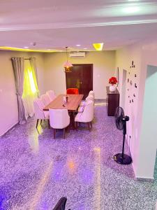 a dining room with a table and white chairs at Shortlet247 in Hausa