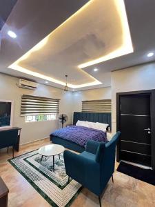a bedroom with a bed and a couch and a table at Shortlet247 in Hausa