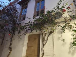 a door on a white building with flowers at ISIDORA home in Rethymno