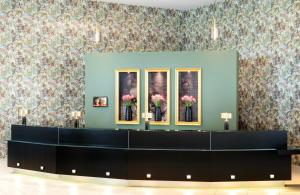 a waiting room with a blue wall with flowers at Leonardo Royal Hotel Munich in Munich