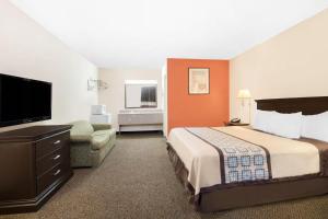 a hotel room with a bed and a flat screen tv at Americas Best Value Inn Hobbs in Hobbs