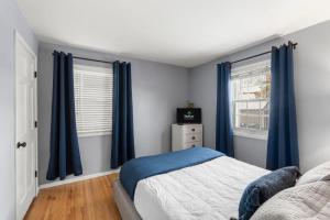 a bedroom with blue curtains and a bed and a window at The Nicollet Nook Unit 2 in Minneapolis +13 photos
