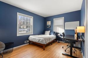a bedroom with blue walls and a bed and a desk at The Nicollet Nook Unit 2 in Minneapolis
