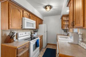a kitchen with white appliances and wooden cabinets at The Nicollet Nook Unit 2 in Minneapolis