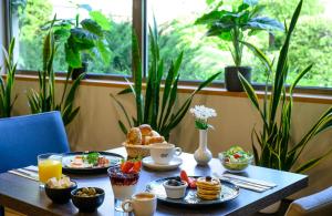 a table with breakfast food on it with plants at Leonardo Hotel Budapest in Budapest