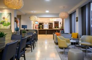 a restaurant with tables and chairs and a bar at Leonardo Hotel Budapest in Budapest