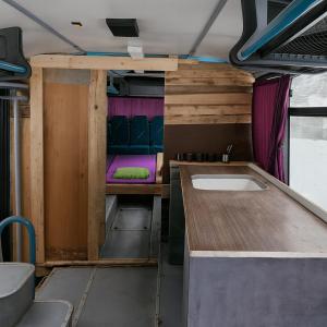a kitchen with a table and a sink in a van at Bed in Bus in Kolárovice