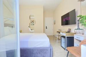 a room with a bed and a desk and a tv at Jera Rooms in Durrës