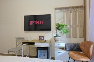 a bedroom with a desk and a tv on a wall at Jera Rooms in Durrës