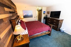 a bedroom with a bed and a dresser and a television at Ski in out King bed Suite Mountain View in Kirkwood